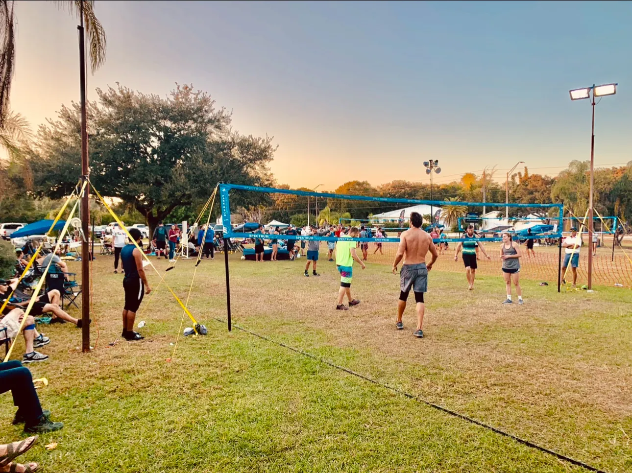 Players and spectators at our grass volleyball tournament at sunset